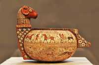 239 Vase à cosmétique - Un jeune homme tient 2 chevaux & deux autres sont dans un char (6° siècle)